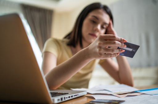 Mulher estressada olhando o cartão de crédito