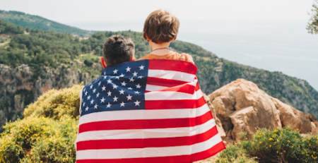 Pai e filho com a bandeira dos EUA olhando a paisagem