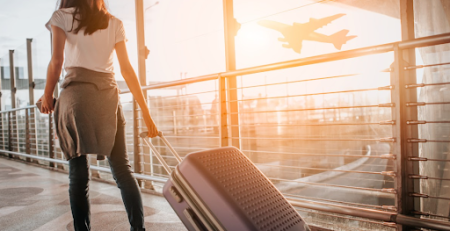 Jovem segurando mala em aeroporto