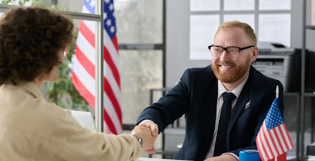 Homem e mulher apertando as mãos após entrevista para visto americano