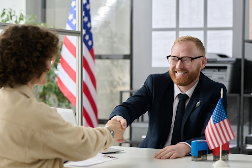 Homem e mulher apertando as mãos após entrevista para visto americano
