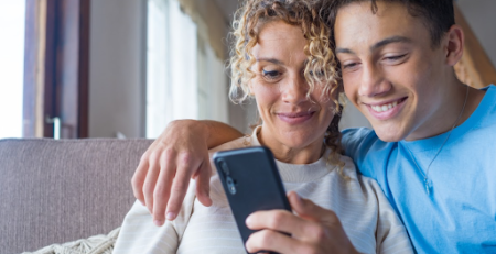 Mãe e filho vendo no celular visto de acompanhante