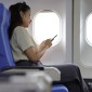 Mulher em avião vendo no celular visto de transito