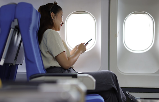 Mulher em avião vendo no celular visto de transito